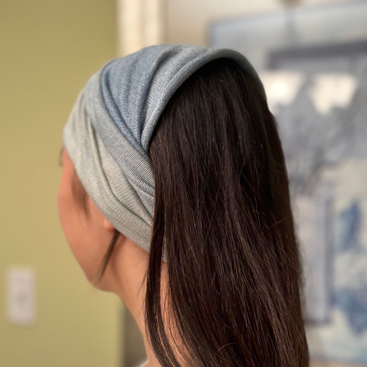 woman is wearing light-blue silk headband.
