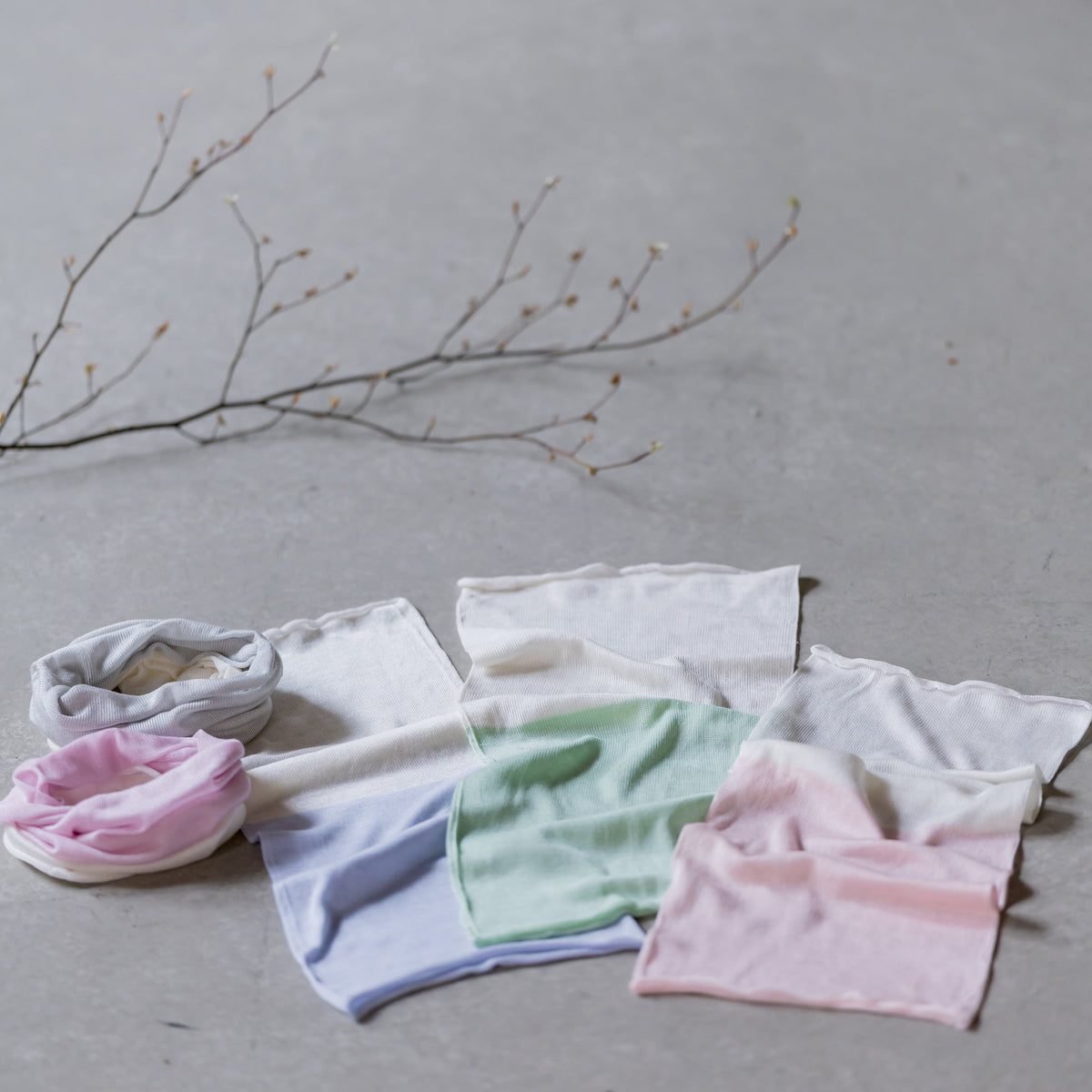 Set of colorful baby headbands and accessories on a neutral background with a branch.