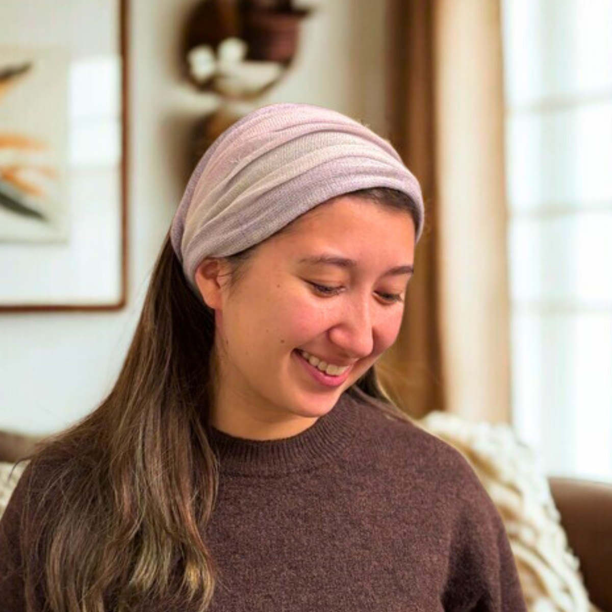 Woman wearing a lavender headband indoors with a blurred background