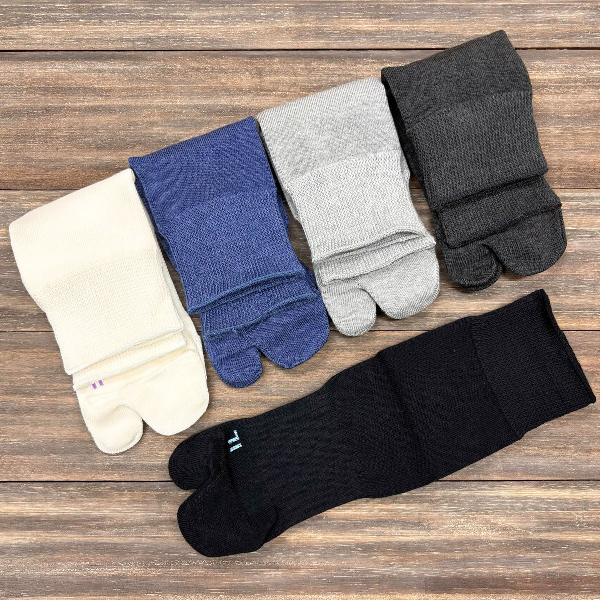 Set of five pairs of tabi socks in different colors on a wooden surface