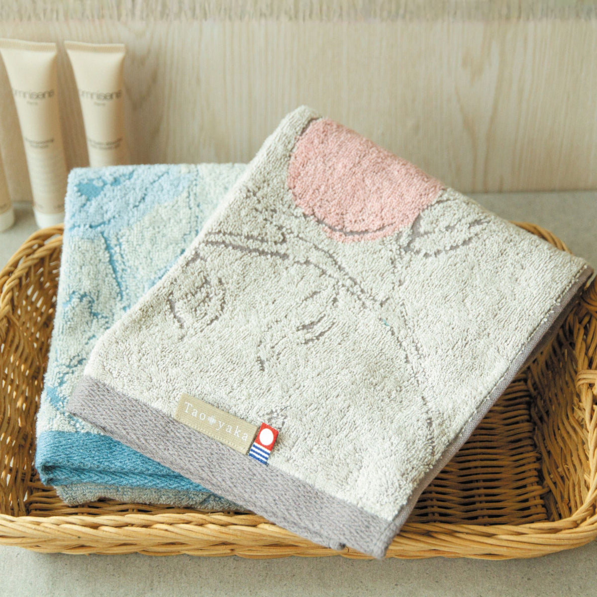 Two towels with floral patterns in a basket on a light background.