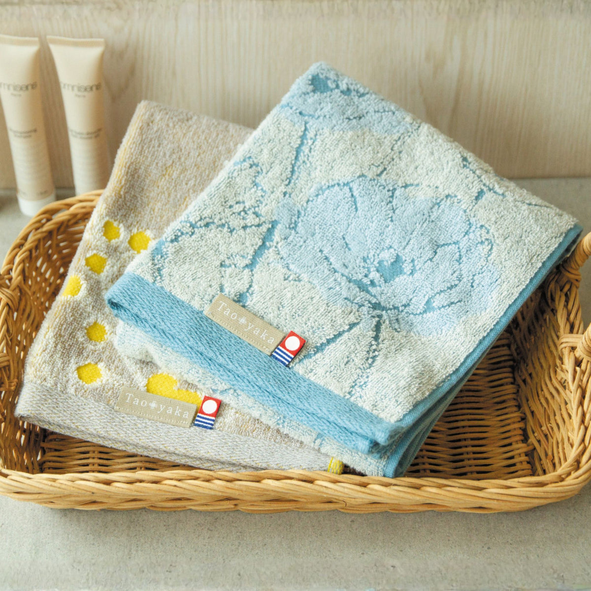 Two towels with floral patterns in a basket on a light background.