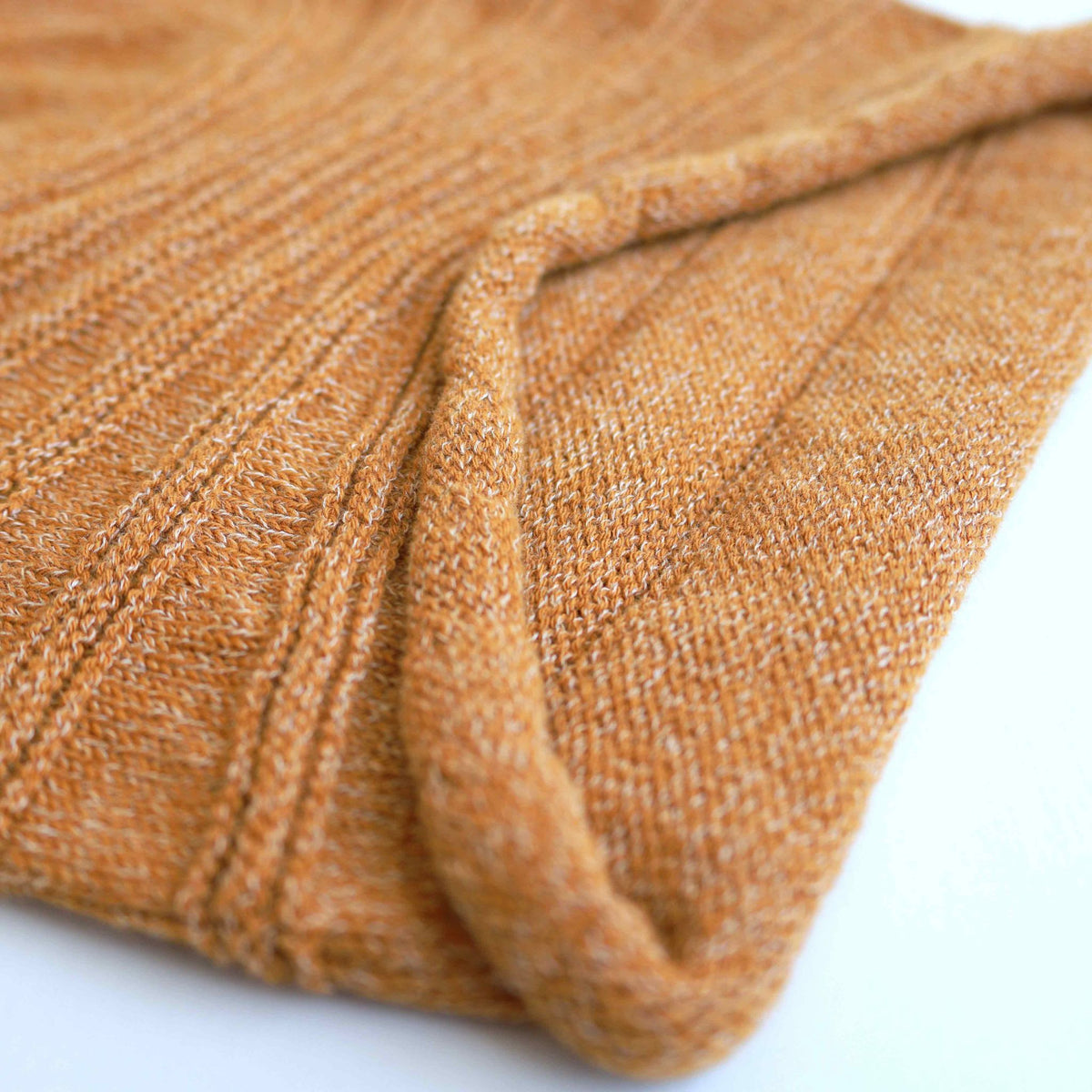 Close-up of a textured mustard fabric on a white background
