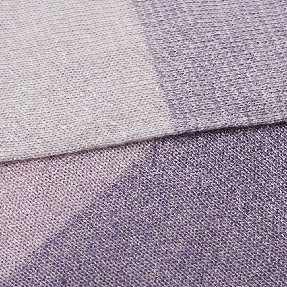 Close-up of a fabric with a gradient of light gray to purple.