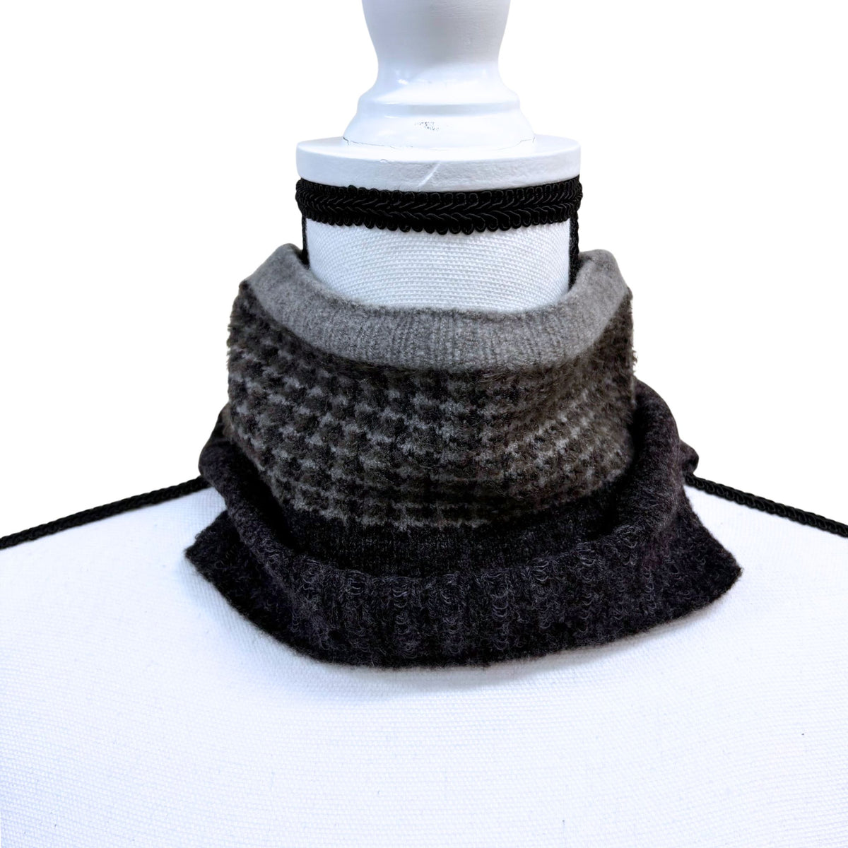 Stack of gray and black patterned scarves on a white background
