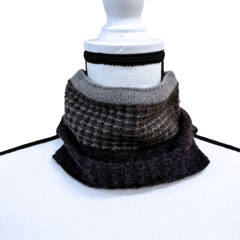Stack of gray and black patterned scarves on a white background