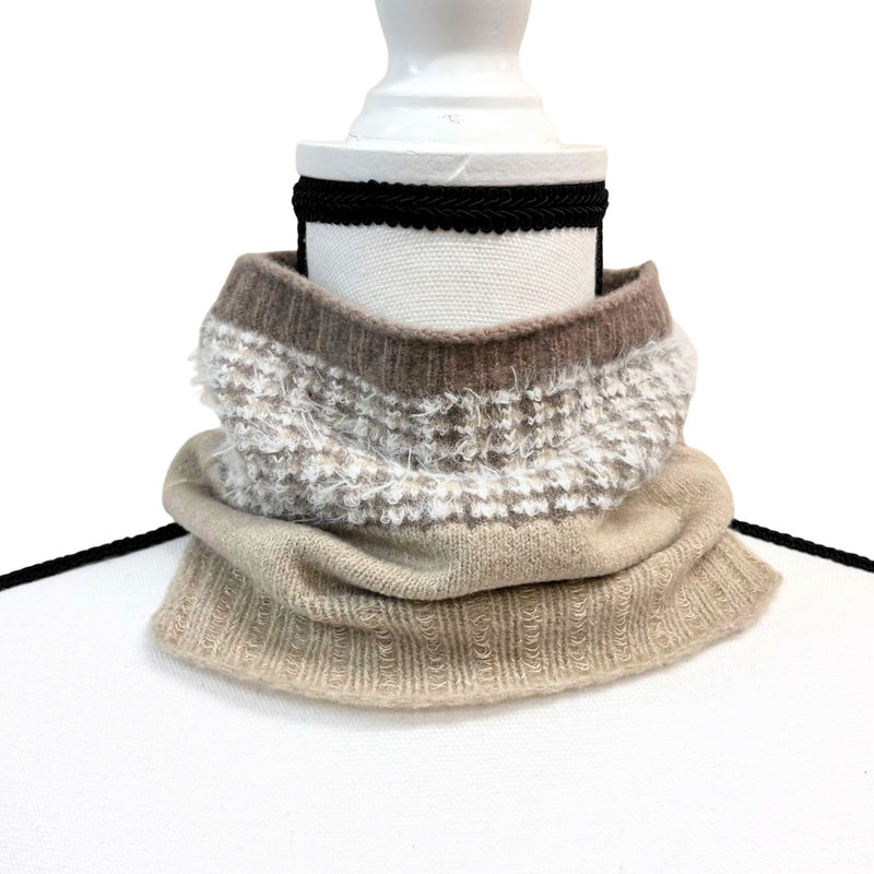 Knitted cowl in beige and white pattern on a mannequin with a white background