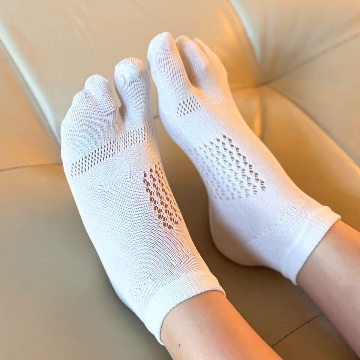 White socks with toe separation on a beige surface
