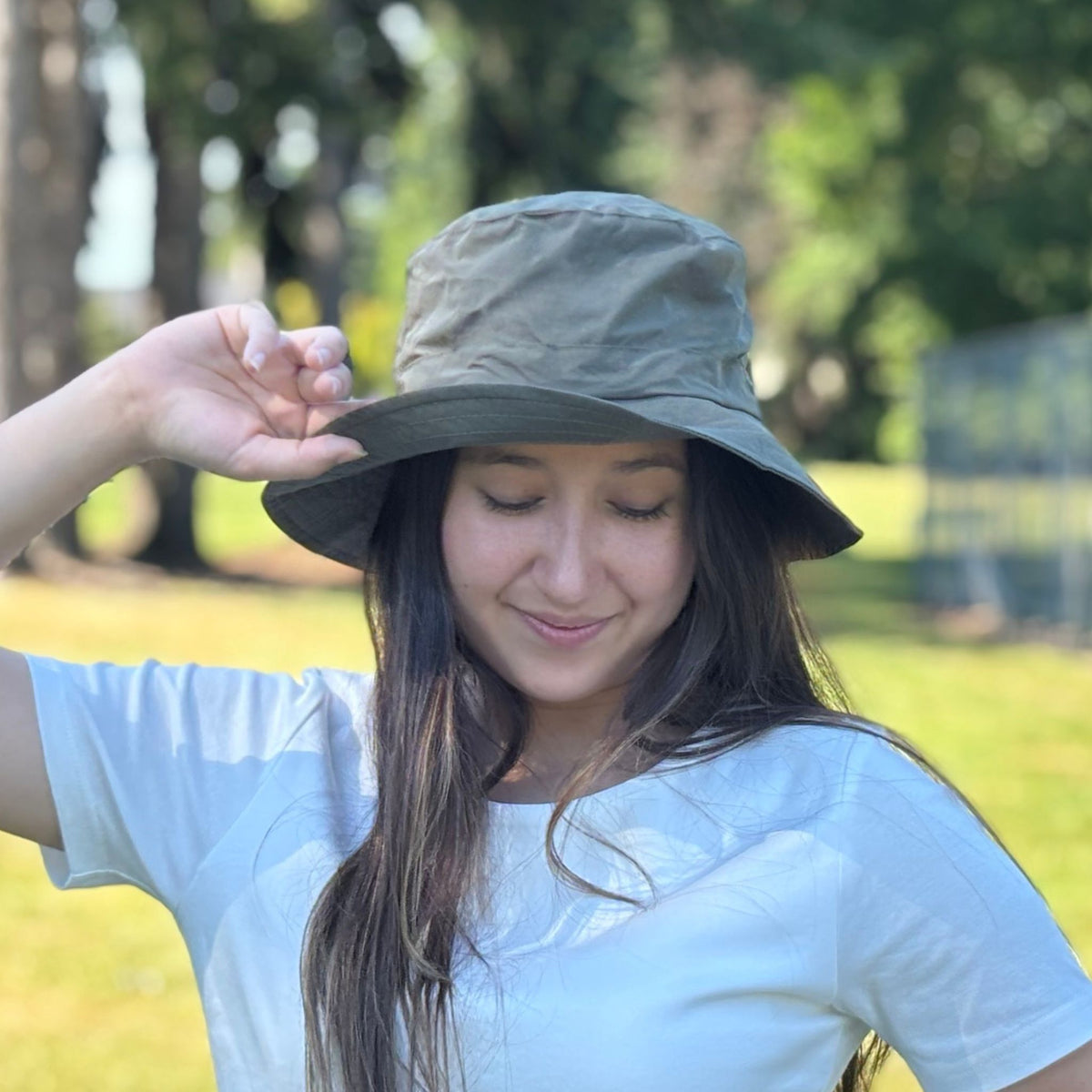 Woman wearing a wide-brimmed hat in a park setting
