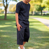 Person wearing a navy loungewear in a park with trees and grass .ear