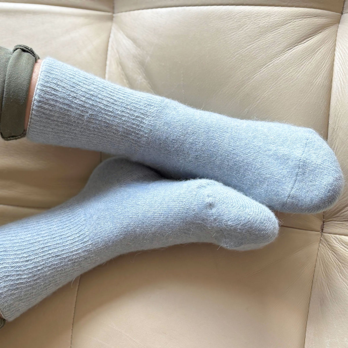 A pair of light blue heathered crew socks shown against a plain white background.