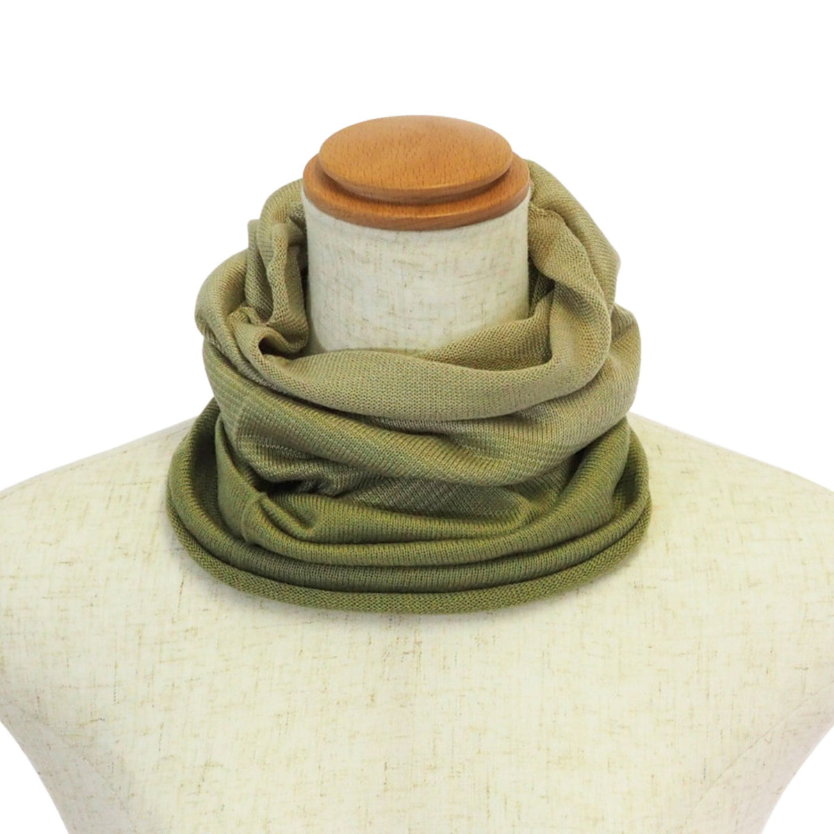 Green scarf wrapped around a mannequin neck on a white background