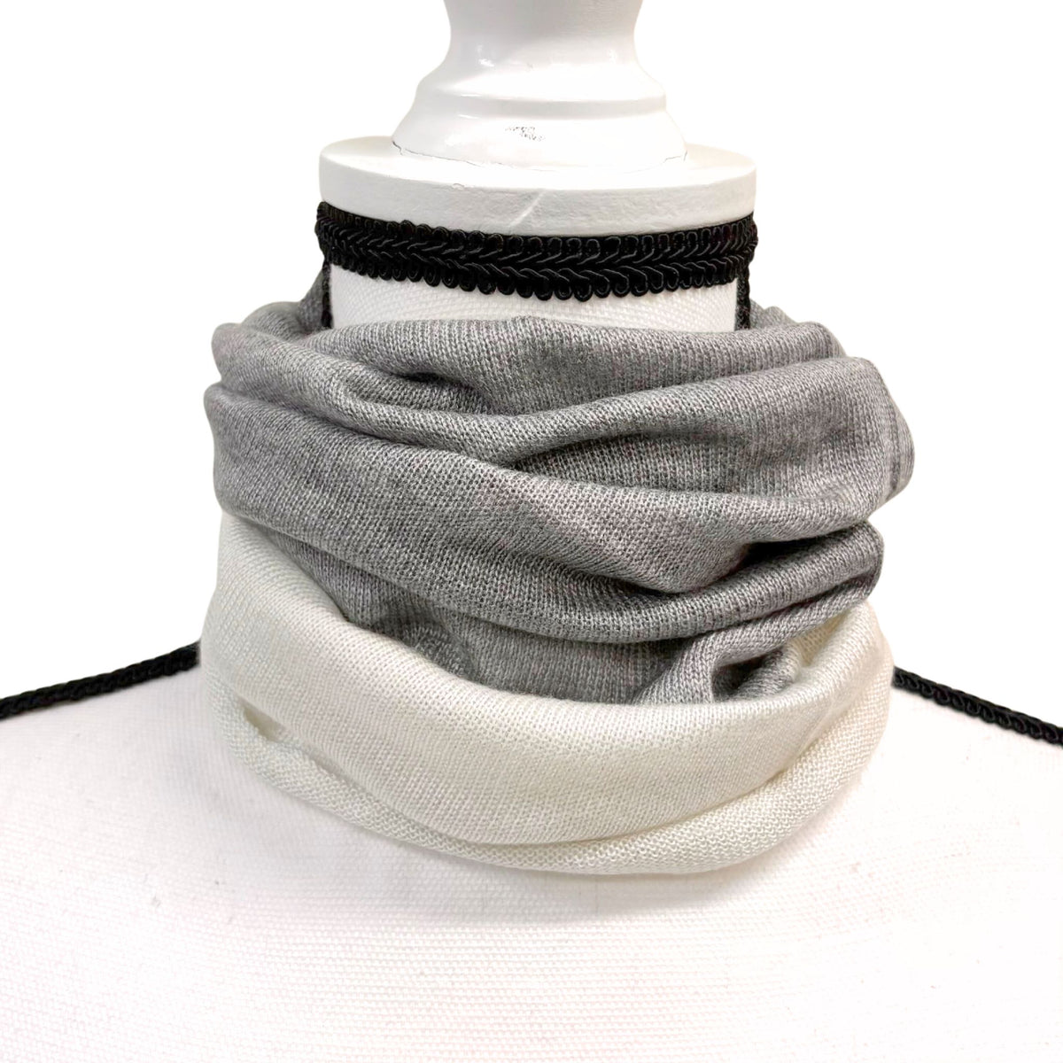 Gray and white scarf on a mannequin with a white background