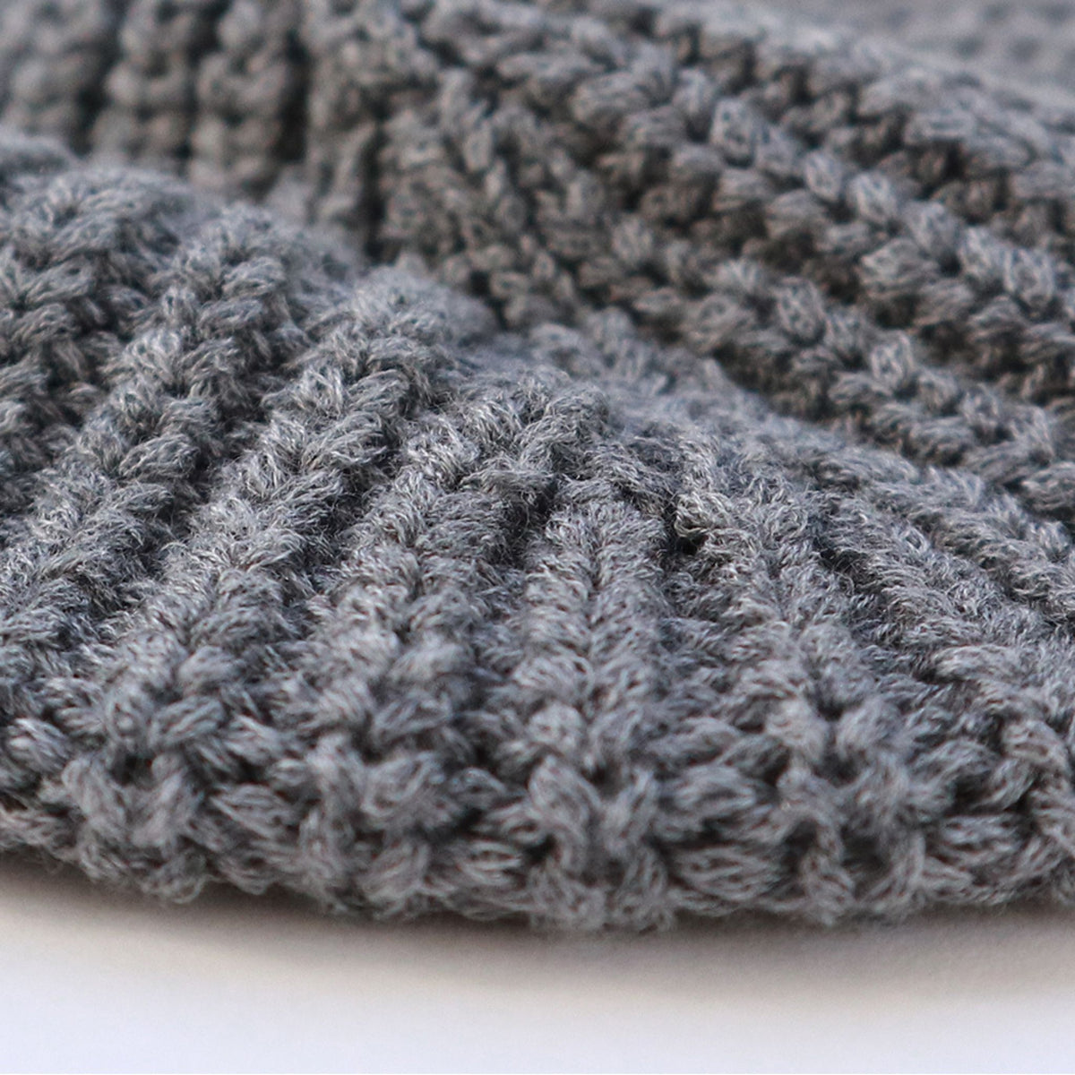 Close-up of a textured gray beret with a subtle pattern