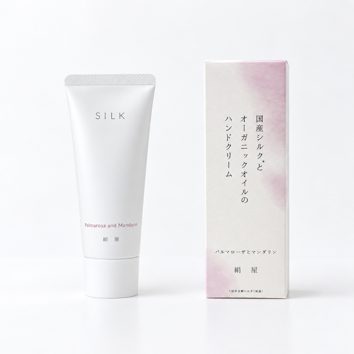 A white skincare hand cream tube labeled 'SILK' stands next to its matching white and pale pink packaging box on a clean white background.