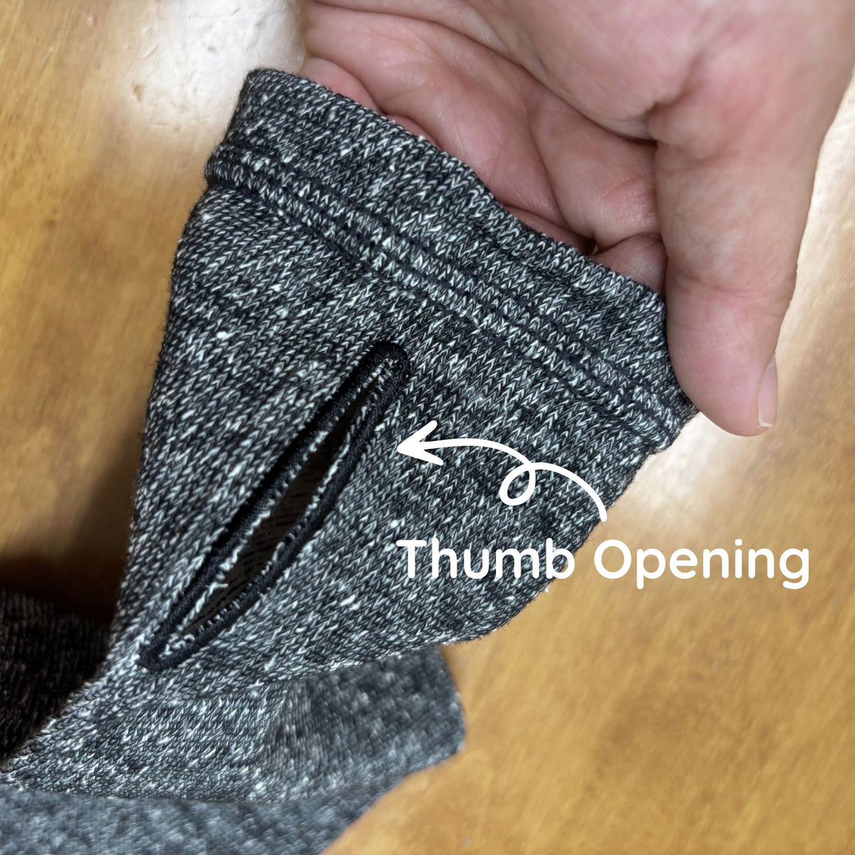 Arm Cover Sleeves with a thumb opening labeled on a wooden surface