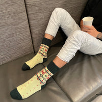 Warm Nordic Slipper Crew Socks made from a merino wool blend with thick ribbed cuffs to block cold air and a brushed lining for added cushioning. The soles feature invisible non-slip grips. Available in four stylish colors, perfect as a gift or for cozy days at home.