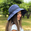 woman wearing a blue visor-back hat in an outdoor setting.