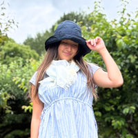 woman wearing a black sun hat in a garden.