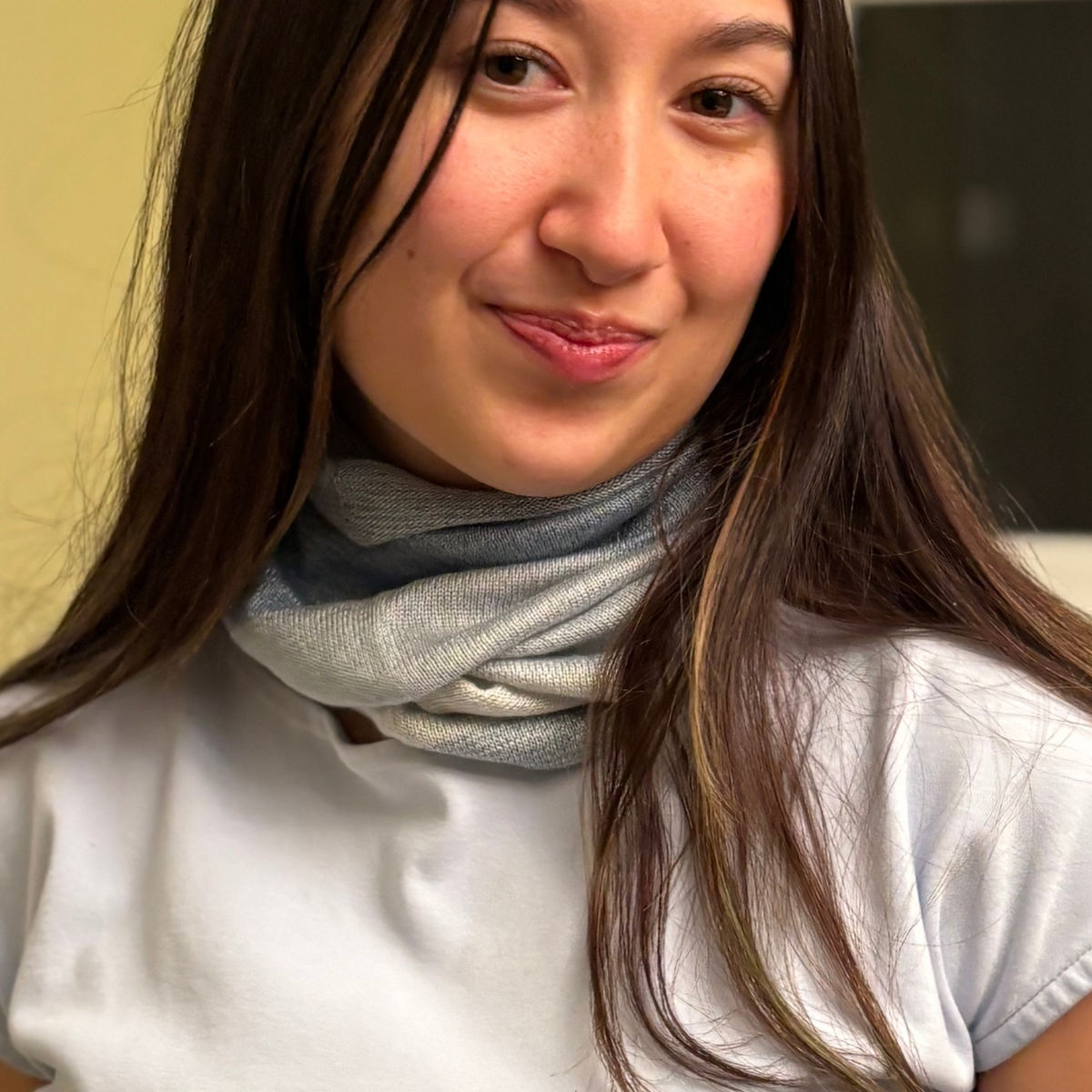 Woman wearing a light blue 100% silk neck warmer.