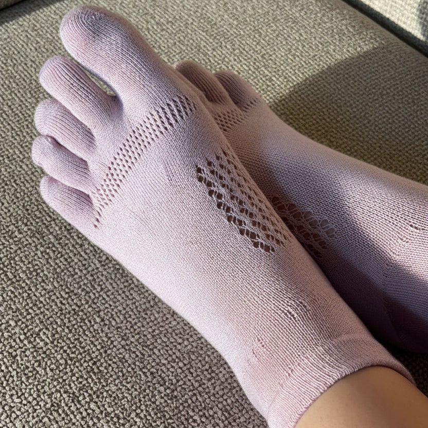 Pink toe-separated socks on couch