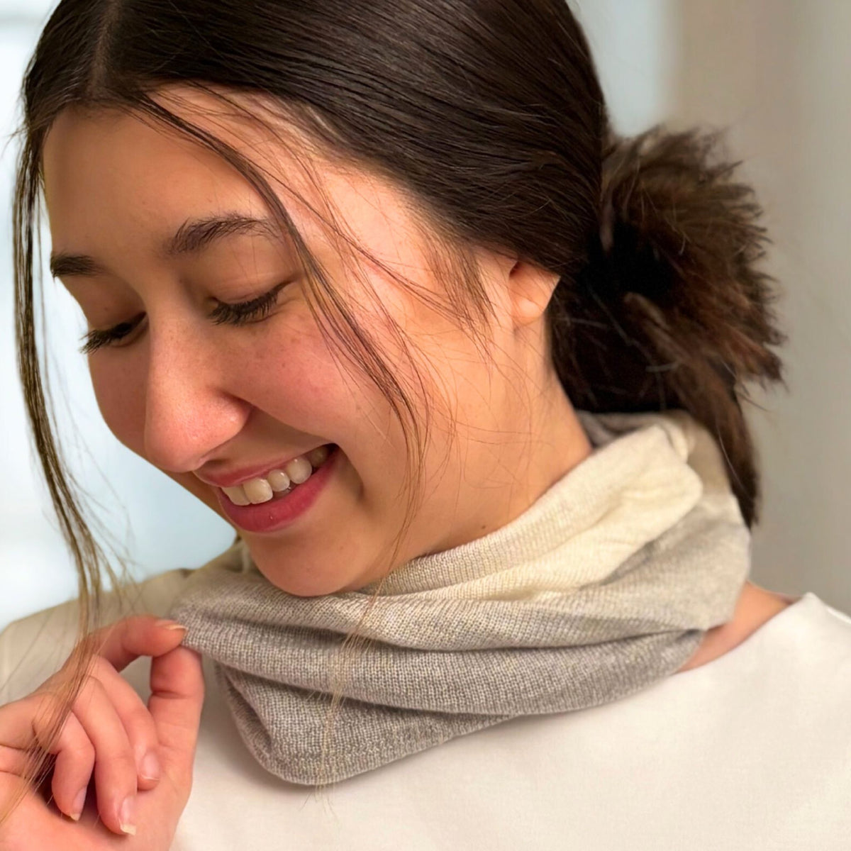 Woman wearing a gray scarf with a blurred background