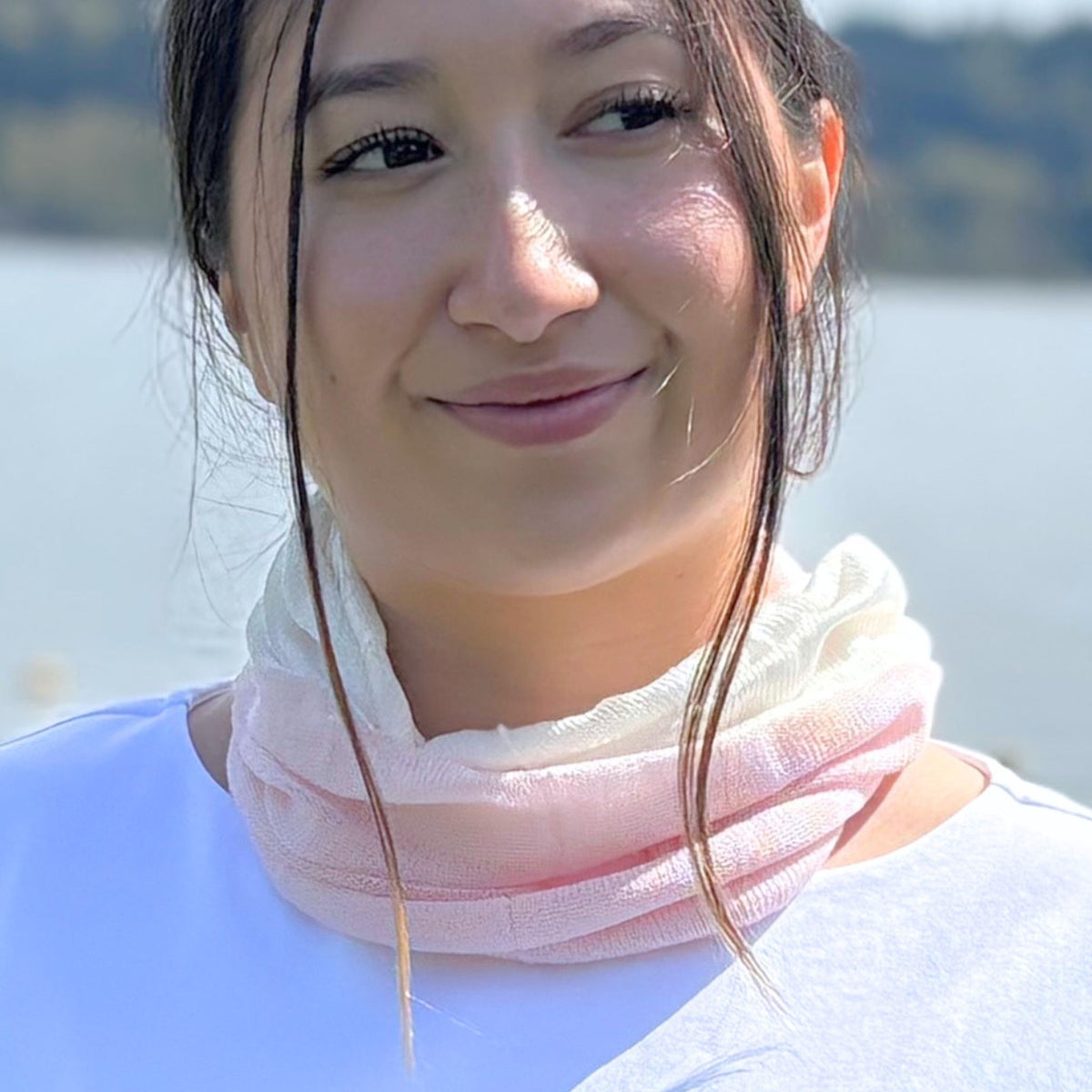 Woman wearing a pink scarf with a blurred natural background