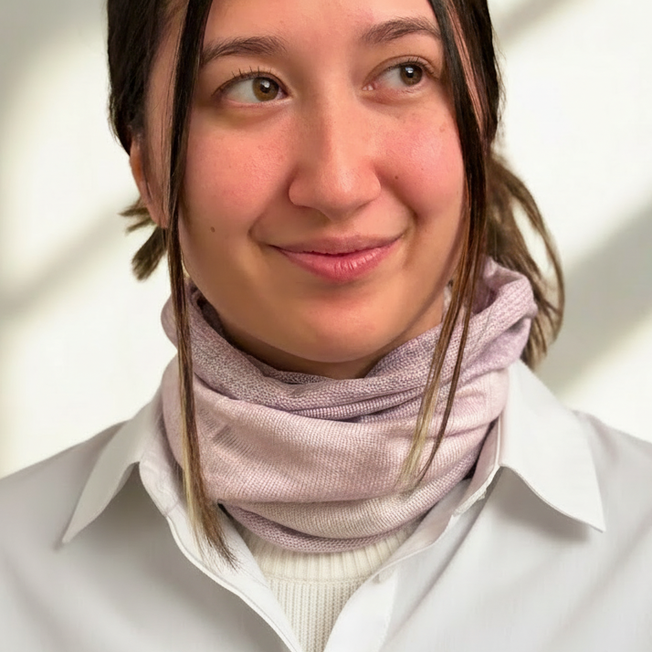 Person wearing a light lavender-colored neck warner against a neutral background