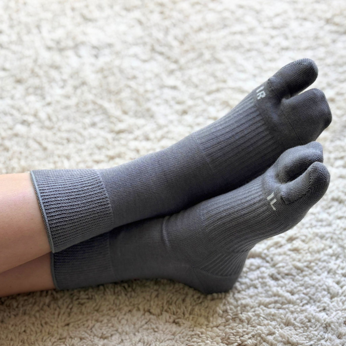 Gray tabi socks worn on a carpet
