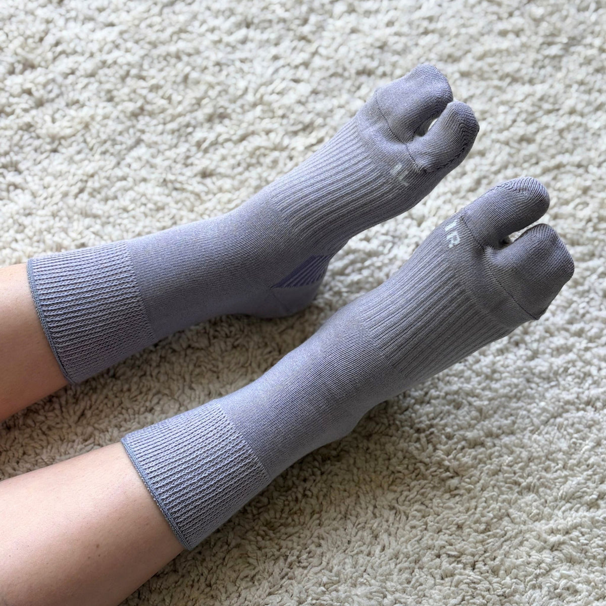Light Violet tabi socks worn on a carpet