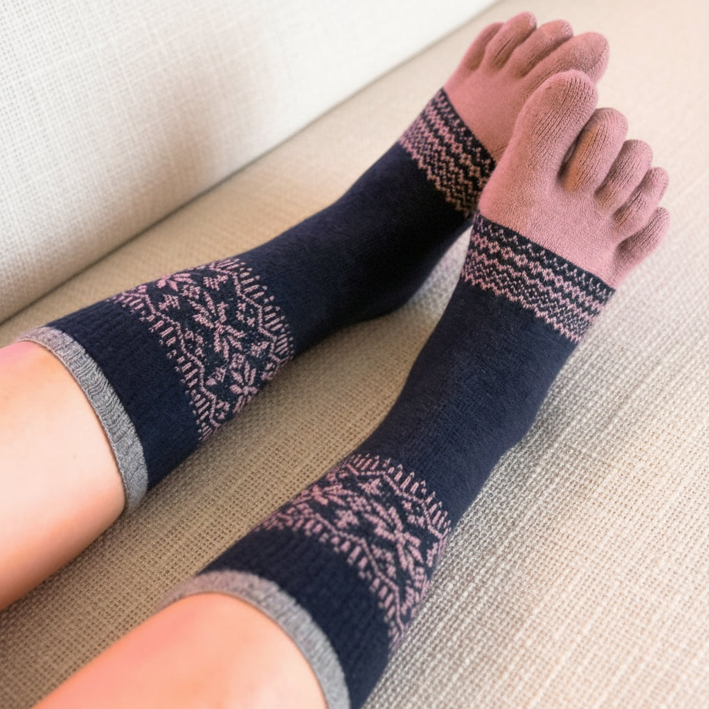 Person wearing dark blue socks with a pattern, sitting on a beige couch.