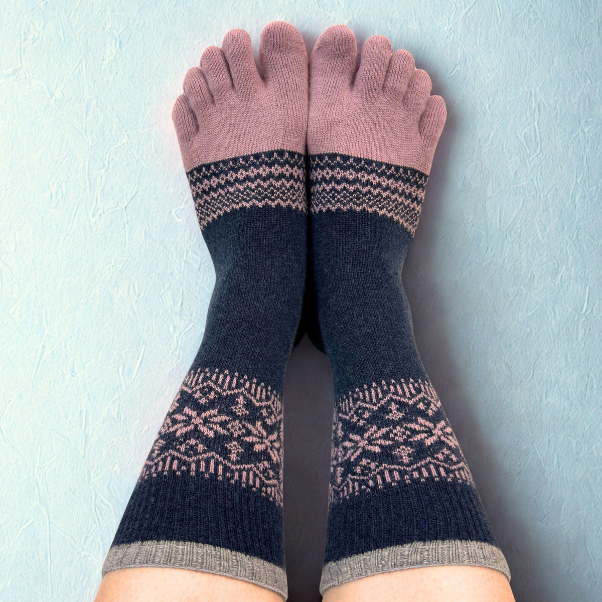 Pair of navy socks with pink patterns on a light blue background