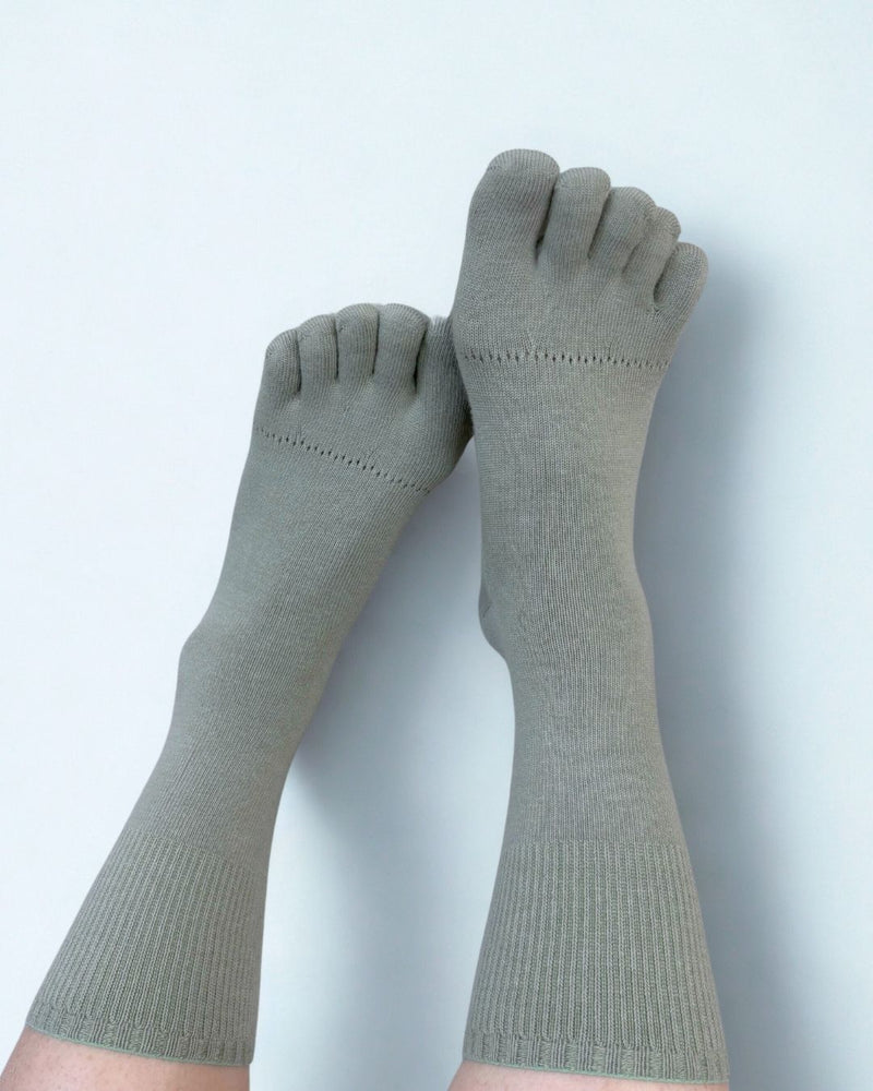 Pair of green toe-separated socks on a white background