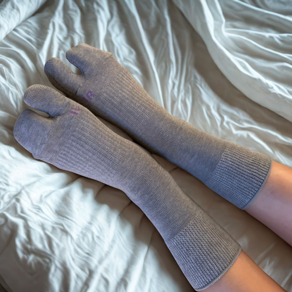Woman is wearing medium size gray tabi socks.